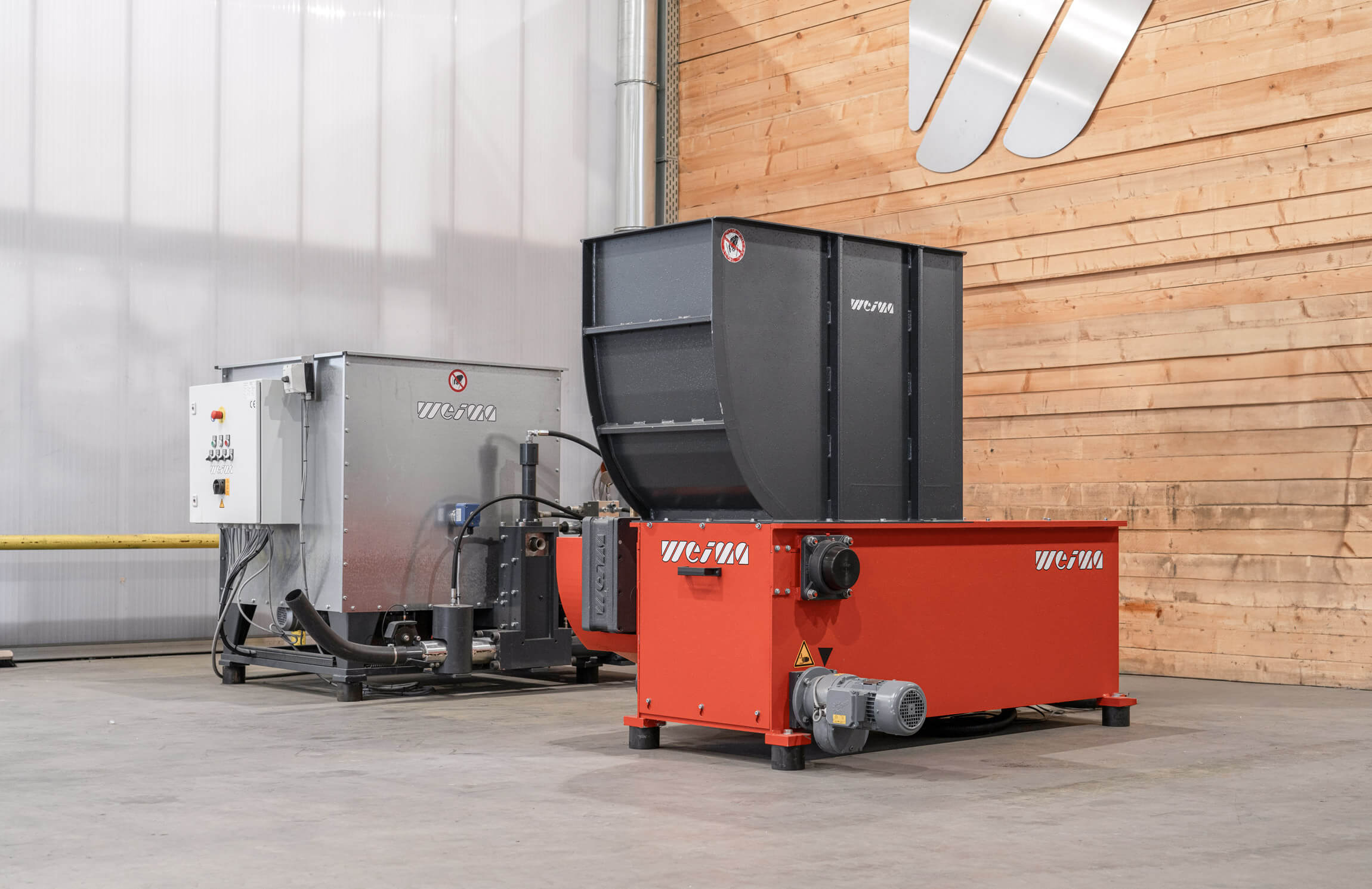 WEIMA showroom in Germany with shredder and briquette press in front of a wooden wall