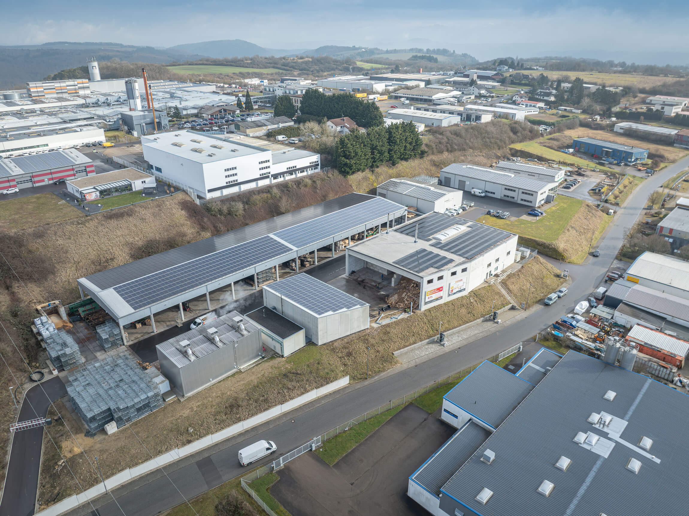 Brennholzwerk Trier company premises within an industrial area photographed from the air.