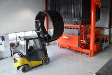Fork lift truck loads huge pipe section into the hopper of the WEIMA WLK 30 Super Jumbo Shredder