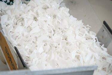 Shredded IBC containers on a conveyor belt