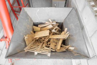 Großer Stapel Holzreste im Trichter eines Shredders