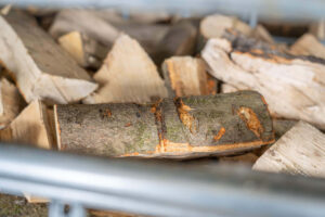Gespaltenes, trockenes Brennholz in einer Gitterbox.